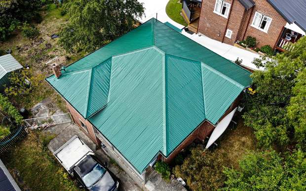 Residential home with a freshly coated green metal roof