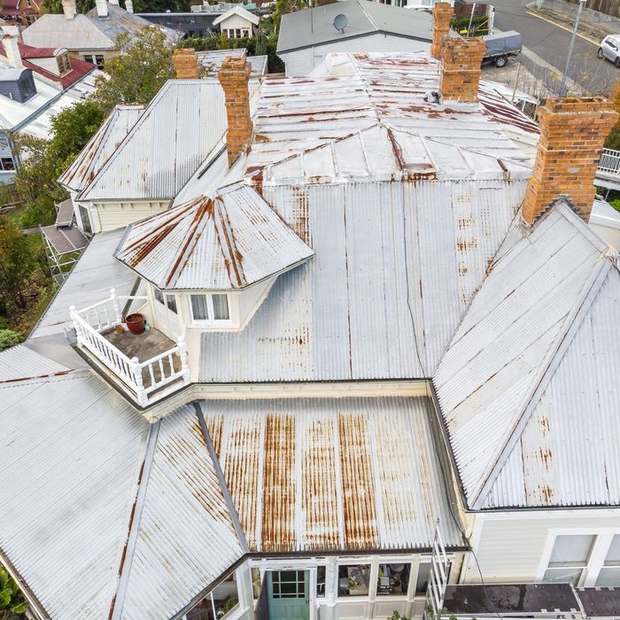 Heritage iron roof before restoration — rust and failed coating